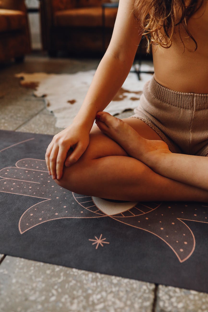 photo of a woman meditating on a black yoga mat